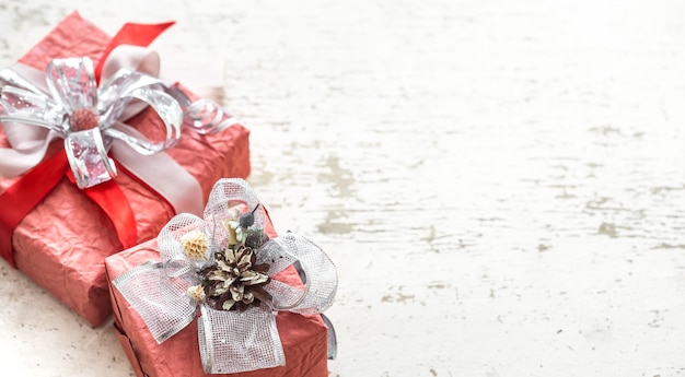 Festive beautiful gift boxes with a bow on a light wooden background.