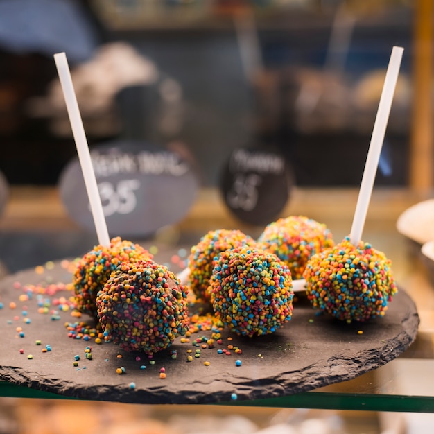 Free photo festive chocolate cake pops with candy sprinkles displayed in the coffee shop