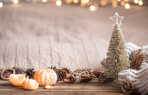 Festive Christmas cozy atmosphere with home decor and tangerines on a wooden background, home comfort concept