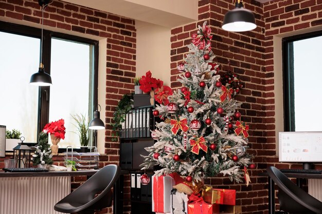 Festive christmas tree and ornaments in company office with no people, empty business workplace filled with seasonal decorations. Holiday decor to celebrate winter season at corporate job.