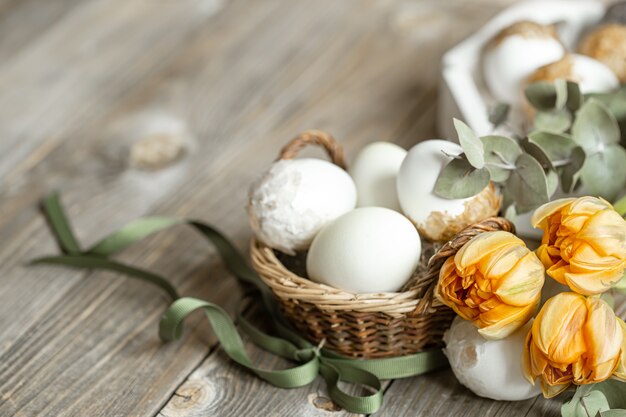 新鮮な春の花と卵でイースター休暇のためのお祝いの構成。イースターの装飾のコンセプト。
