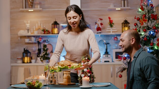 Festive couple preparing for christmas eve dinner at home