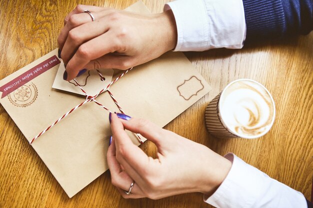 festive decoration with women's hands New Year's letter in an envelope and a glass 