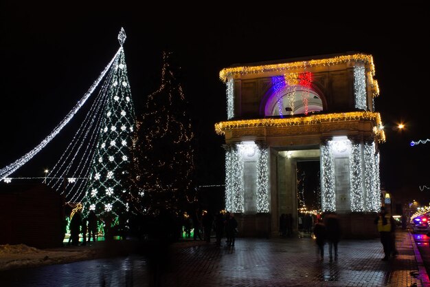 無料写真 凱旋門近くのお祝いの飾り灯とクリスマスツリー