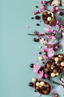 Праздничный пасхальный фон шоколадные сладости перепелиные яйца и цветущий миндаль
