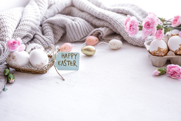 Festive Easter composition with eggs, flowers and the inscription Happy Easter copy space