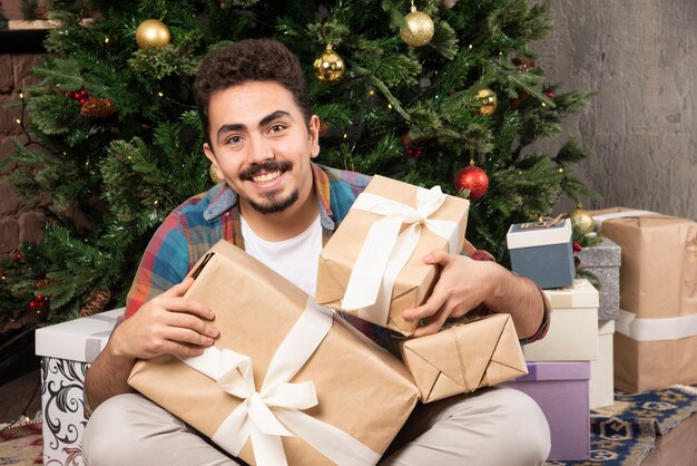 Festive man holding christmas gifts.