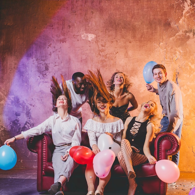 Festive men and women holding balloons