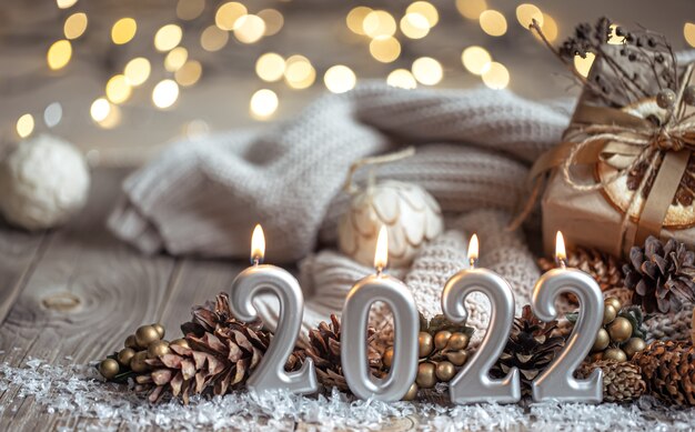 数字2022の形でキャンドルとお祝いの新年の背景。