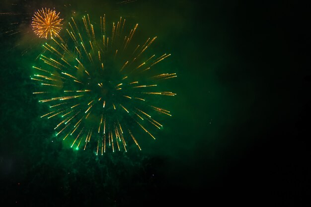暗い空でお祝いの新年の花火 明るい光がきらめきます プレミアム写真
