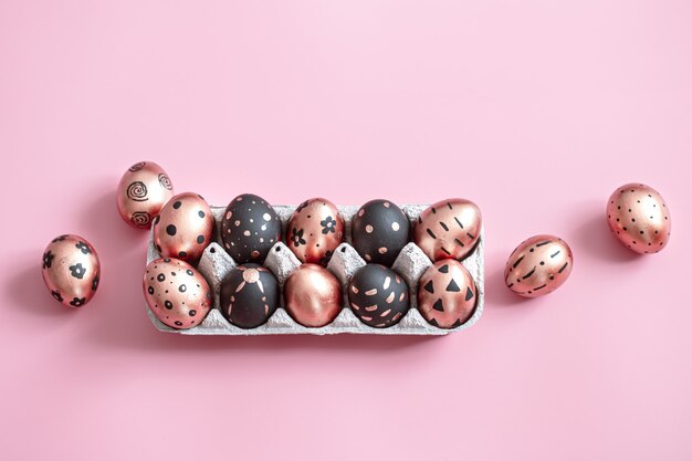 Festive painted in gold and black Easter eggs on pink.