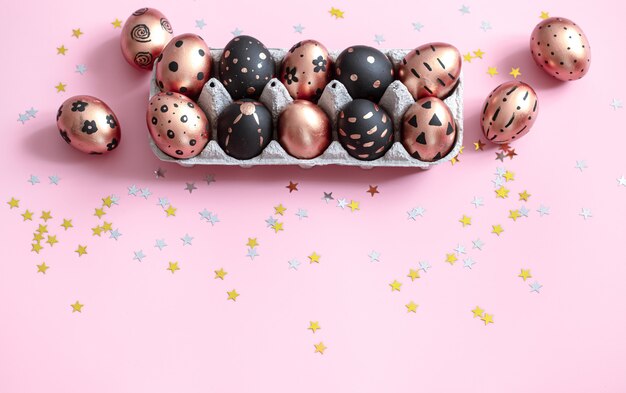 Festive painted in gold and black Easter eggs on pink