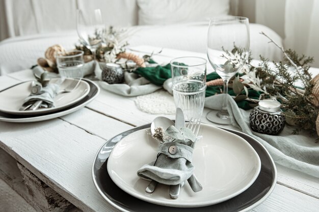 스칸디나비아 장식 세부 사항과 함께 집에서 축제 테이블 설정을 닫습니다.