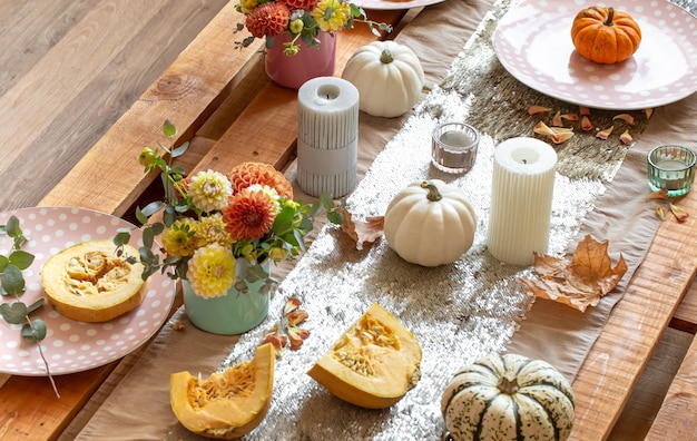 Festive table setting with pumpkins and chrysanthemum flowers