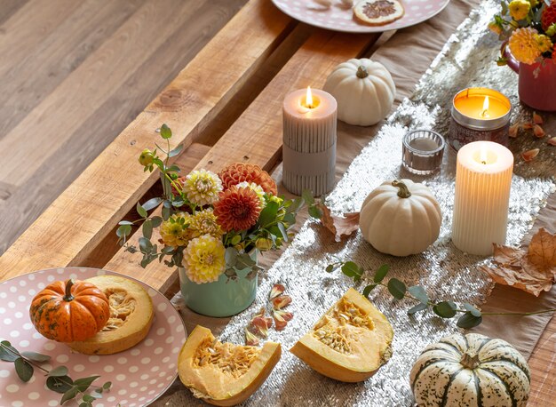 Festive table setting with pumpkins and chrysanthemum flowers