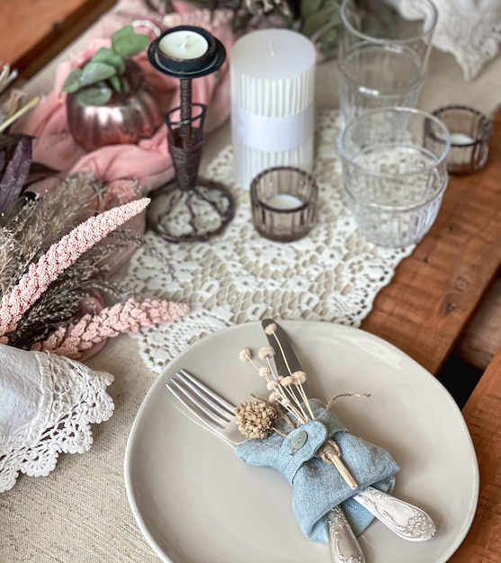 Festive table setting with sprigs of dried flowers and decorative elements.