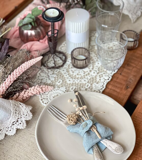 Festive table setting with sprigs of dried flowers and decorative elements.