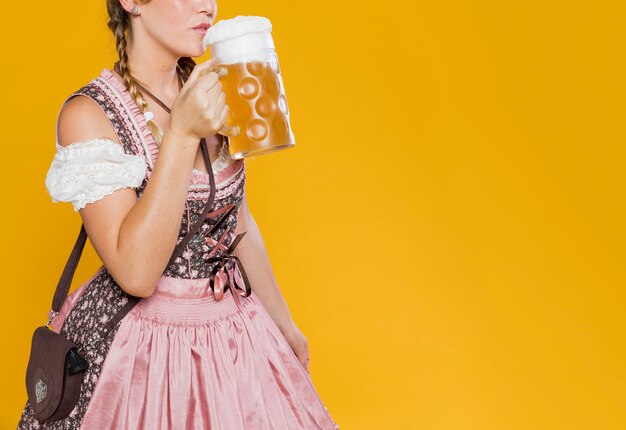 Festive woman in costume ready to drink beer