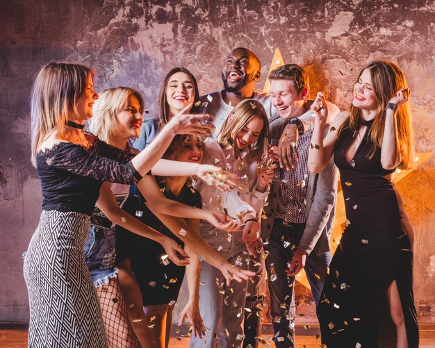 Festive young friends having fun with confetti