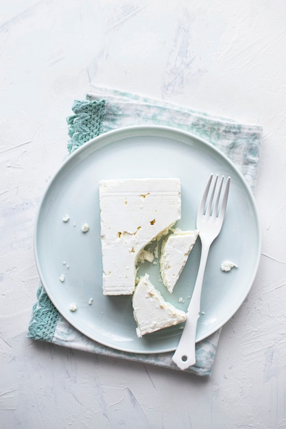 Free photo feta cheese on a  white plate with fork flat lay