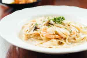 Free photo fettucine white cream sauce with shrimp and mushroom