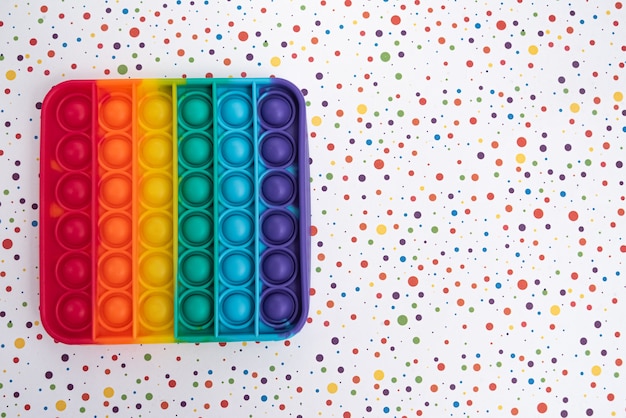 Бесплатное фото Игрушка fidget pop it цвета радуги - антистресс, веселье и познавательная способность