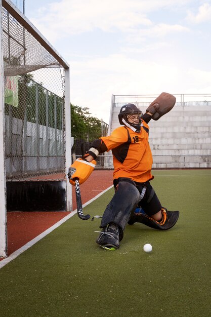 Field hockey player in equipment on the grass