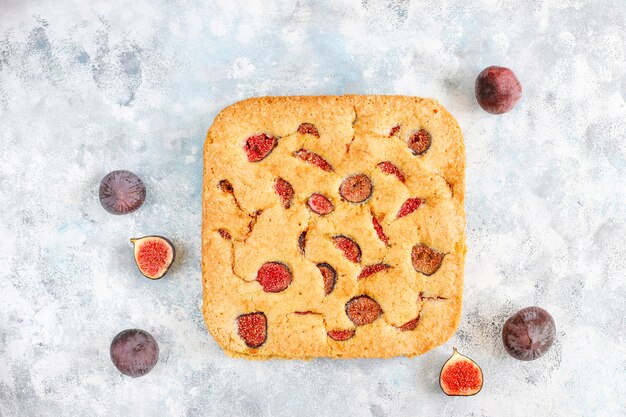 Fig cake with fresh figs on grey concrete background.