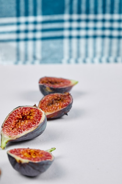 Fig slices on white with a blue tablecloth.