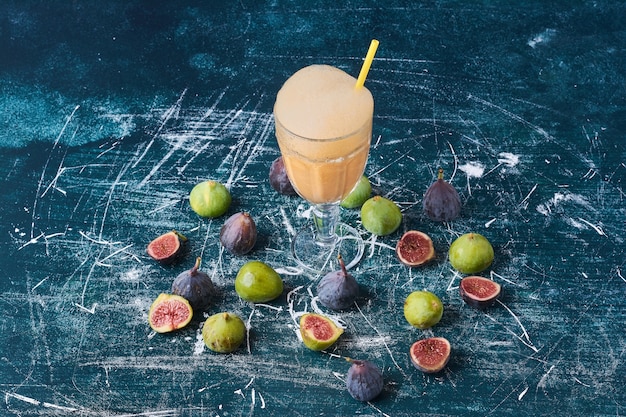 Figs with a cup of drink on blue.