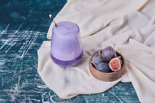 Figs with a cup of drink on blue.