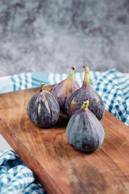 Figs on wooden board with a blue tablecloth.