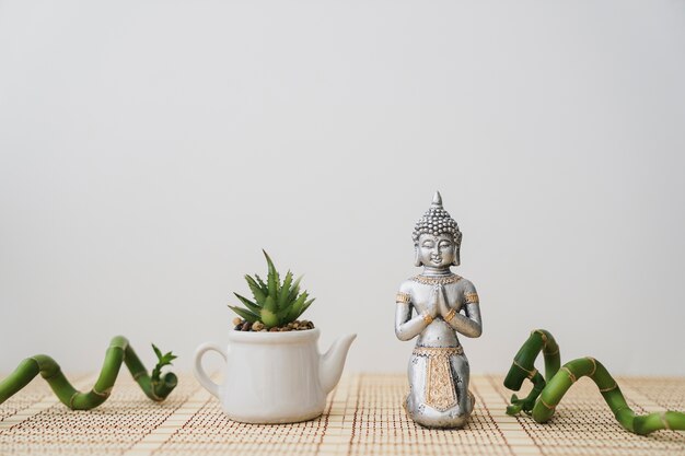 Figure of buddha and pot with decorative bamboo