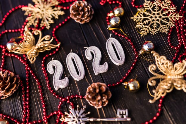 Figure of New Year from red necklace. Spruce branches on wooden boards, top view. Christmas decorations on wooden background. Copy space