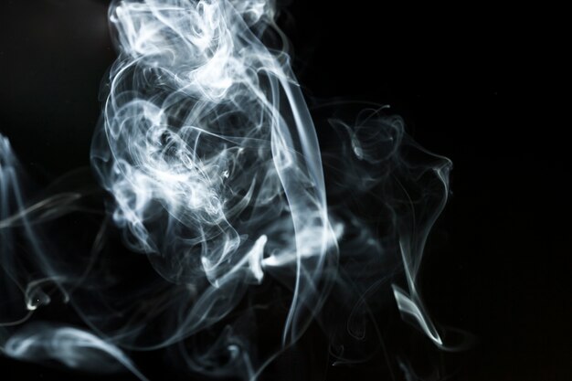 Figures of white smoke on black background