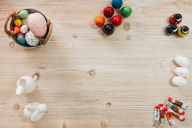 Figurines and eggs with paints on table