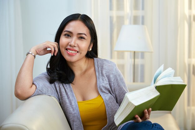 Filipino female with book looking at camera