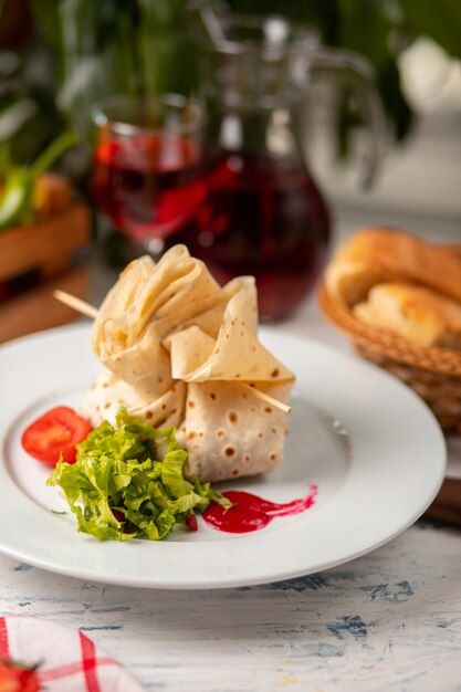 흰 접시에 토마토와 양상추 샐러드와 함께 채워지고 채워진 lavash