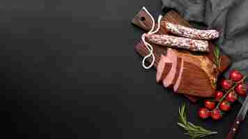 Free photo fillet meat and salami on wooden board with copy-space