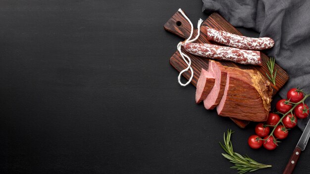 Fillet meat and salami on wooden board with copy-space