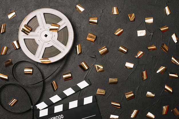 Free photo film, clapperboard and golden confetti