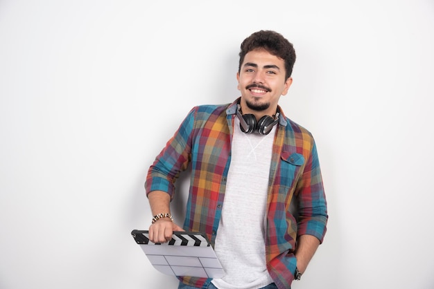 Free photo filmmaker holding a blank white clapper board.