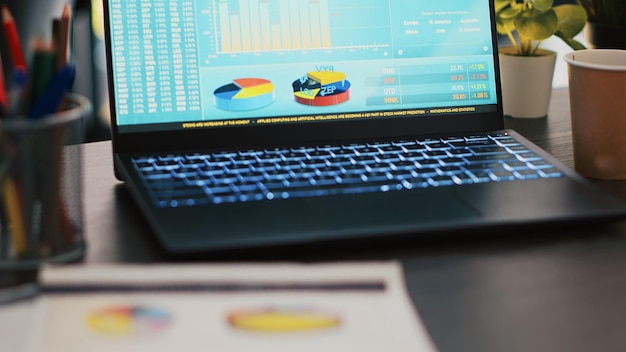 Financial report on desk next to laptop showing marketing statistics in office