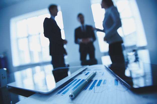 Financial report with co-workers blurred background