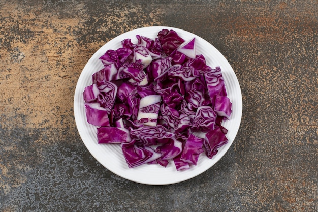 Finely chopped red cabbage in the plate on the marble surface