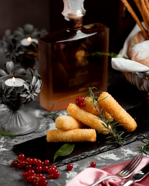 Free photo finger potato nuggets garnished with cranberry and rosemary