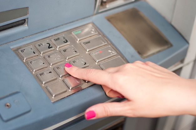 Finger pressing password number on ATM machine