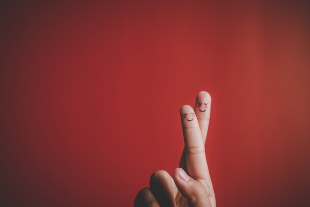 Finger with emotion on red background