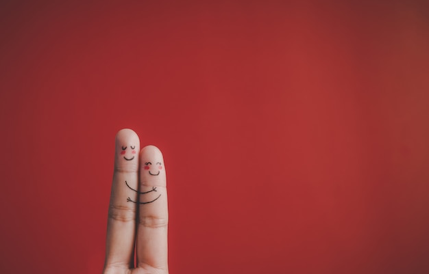 Finger with emotion on red background