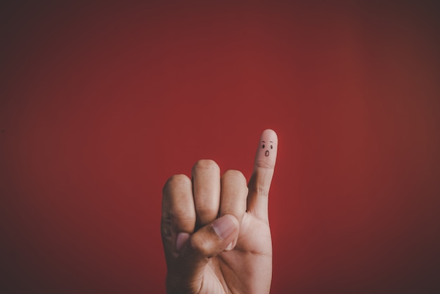 Finger with emotion on red background